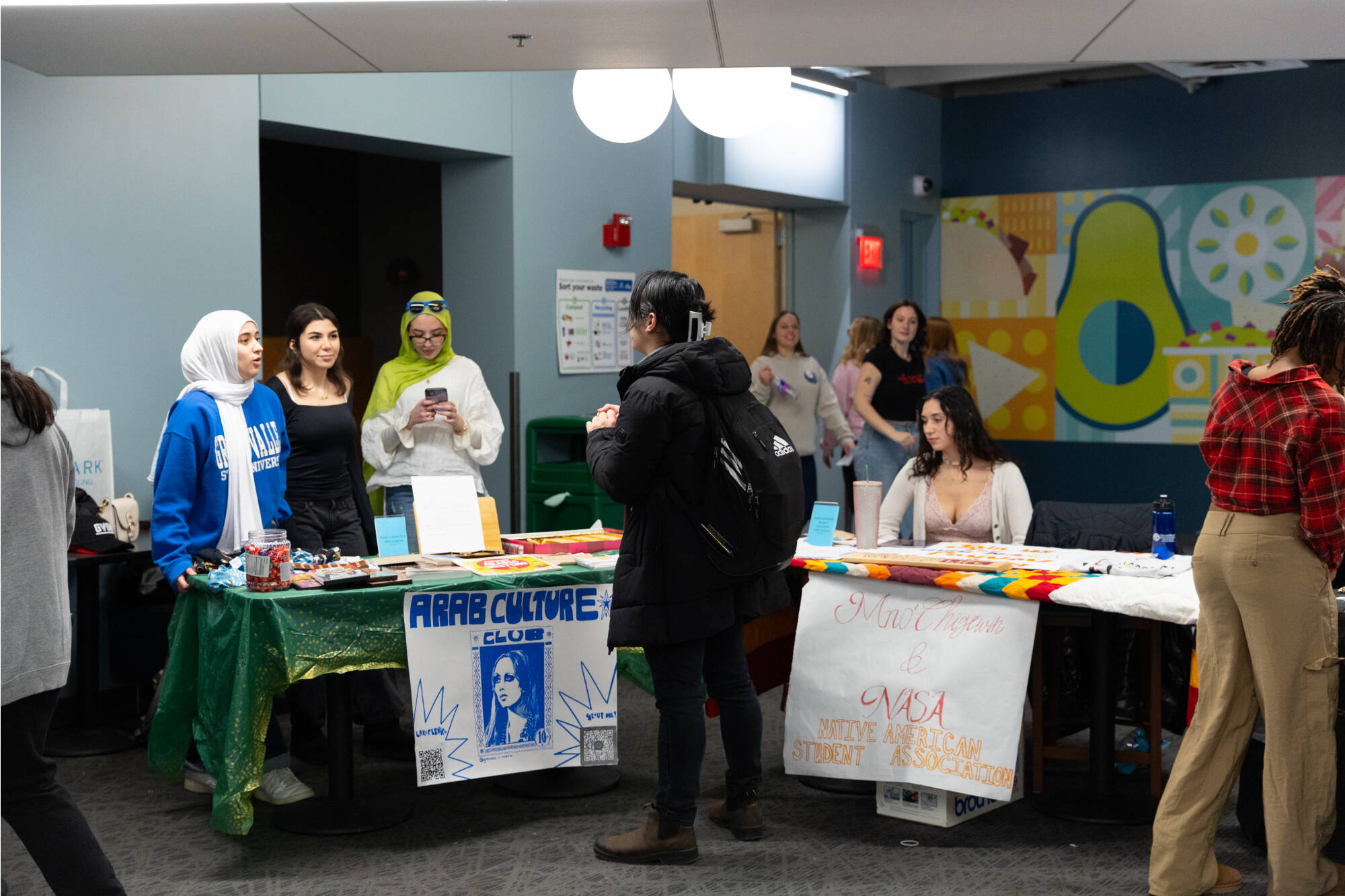 Arab Culture Club members and Native American Student Association members chat with a student